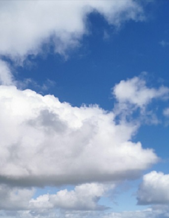 Picture of white fluffy clouds against blue sky.